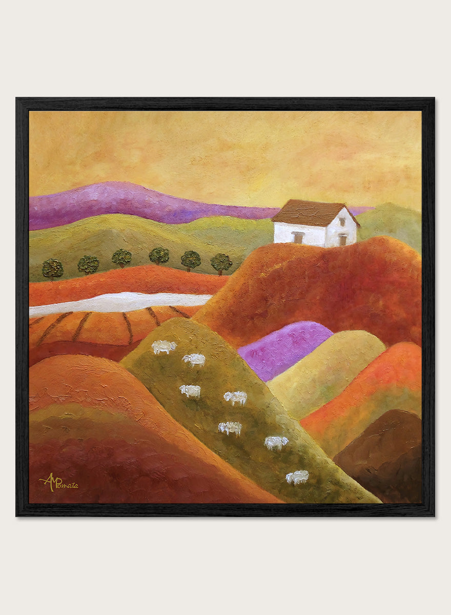 A framed landscape painting featuring rolling hills in warm earth tones, purple and green valleys, a small white house, and white sheep. Shop Pastoral Hills With Sheep by Angeles M. Pomata, an autumn countryside art print featuring rolling hills, grazing sheep, a white farmhouse, and warm earthy tones.