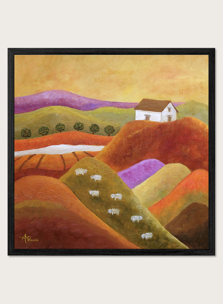 A framed landscape painting featuring rolling hills in warm earth tones, purple and green valleys, a small white house, and white sheep. Shop Pastoral Hills With Sheep by Angeles M. Pomata, an autumn countryside art print featuring rolling hills, grazing sheep, a white farmhouse, and warm earthy tones.