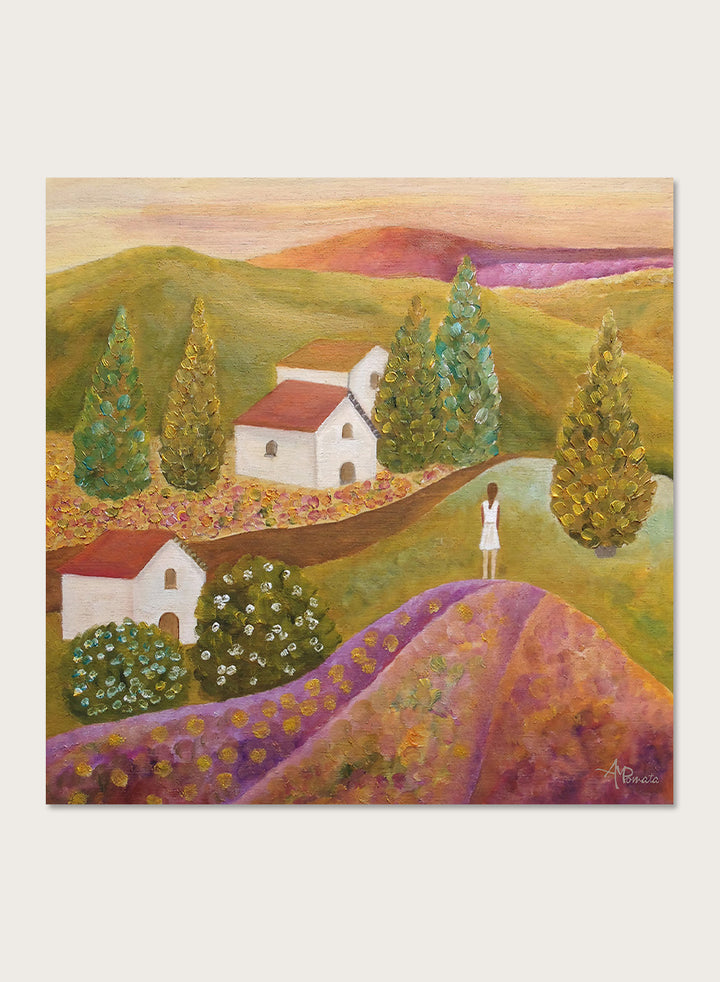 A framed landscape painting featuring rolling green hills, white houses with red roofs, tall conical trees, and a figure standing on a purple field. Shop Woman in Lavender Fields by Angeles M. Pomata, a colorful landscape and figurative art print featuring lavender fields, white houses, cypress trees, and rolling hills.