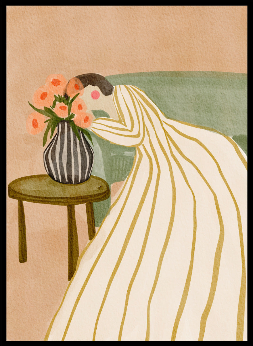 A stylized art print depicting a woman in a cream and gold striped gown leaning over a small table with a striped vase of pink flowers, set against a muted green sofa and beige background. Shop Woman Admiring Flowers by Nikita Jariwala, a modern floral wall art print featuring a woman, peach blooms, striped dress, and warm earthy tones.