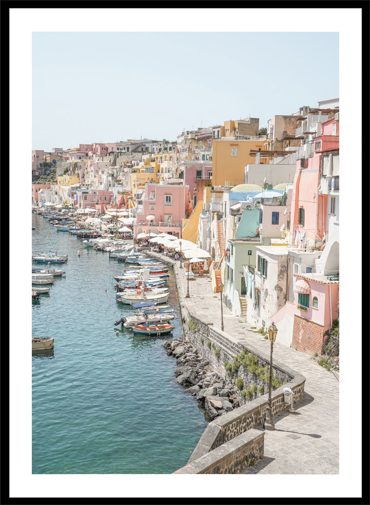 Colorful coastal town with boats docked along a waterfront. Colorful Italian Harbor by Henrike Schenk is a coastal photography print featuring pastel waterfront architecture, fishing boats, turquoise waters, and Mediterranean charm.