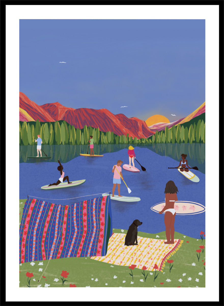 A framed art print featuring a colorful, stylized illustration of people paddleboarding and relaxing on a lake with mountains in the background. Paddleboard Lake Life by Ceyda Alasar outdoor art print featuring paddleboarders, mountain scenery, wildflowers, picnic blankets, and a lakeside dog.