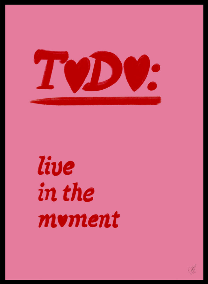 Pink poster with red text 'TODO: live in the moment' on a pink background. Typography wall art reading “live in the moment” with red hearts on pink background by Anne-Marie Volfova. Officially licensed motivational art print.