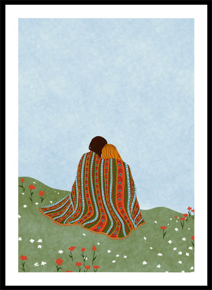 A framed art print featuring an illustration of two people sitting on a grassy hill, wrapped in a vibrant, patterned blanket under a light blue sky. Cozy Hillside Embrace by Ceyda Alasar art print featuring two people wrapped in a patterned blanket among green hills and wildflowers.
