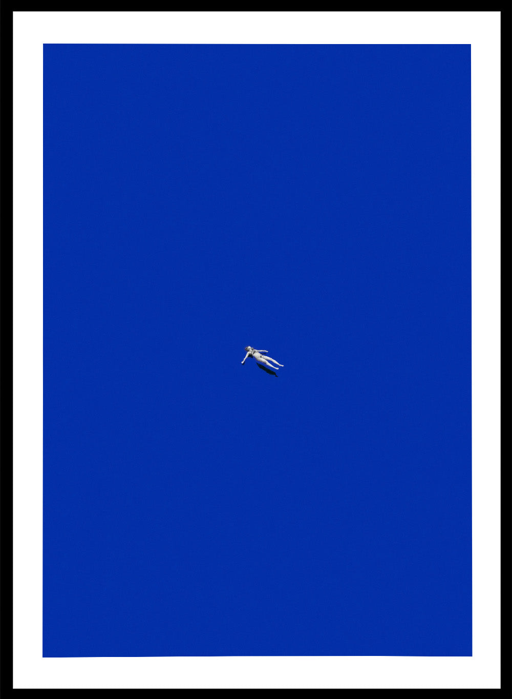 No Stress by Maarten Léon is a minimalist collage art print featuring a floating figure in a bold blue space. Premium fine art print with real wood framing.