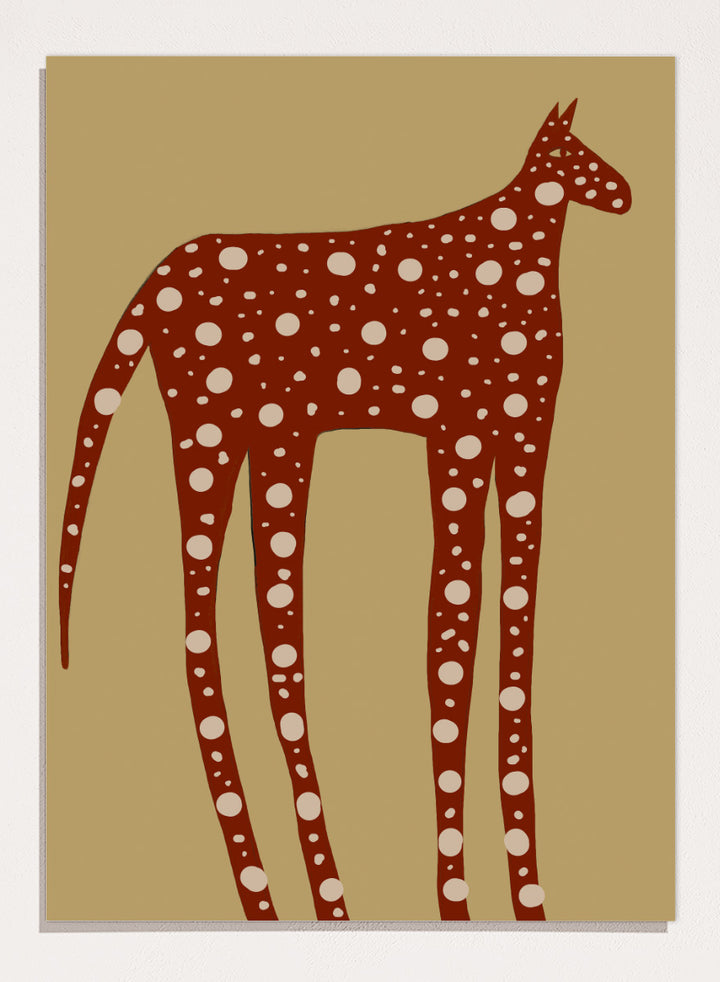 A stylized art print of a giraffe in reddish-brown with white spots, set against a tan background. Spotted Earthy Creature by The Art Concept animal art print featuring a long-legged rust-colored figure with cream spots on a muted tan background.