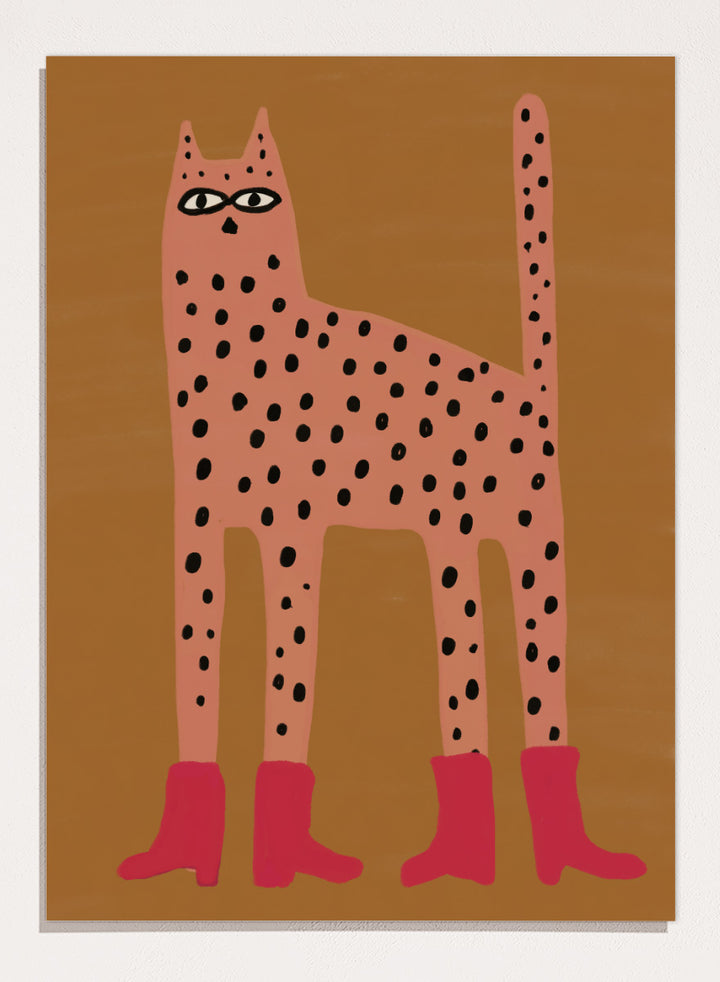 A stylized art print of a tall spotted cat in a pinkish-orange tone with black spots and bright pink boots, set against a warm brown background. Spotted Cat in Boots by The Art Concept playful cat art print featuring a pink spotted cat with long legs, red boots, and a warm ochre background.