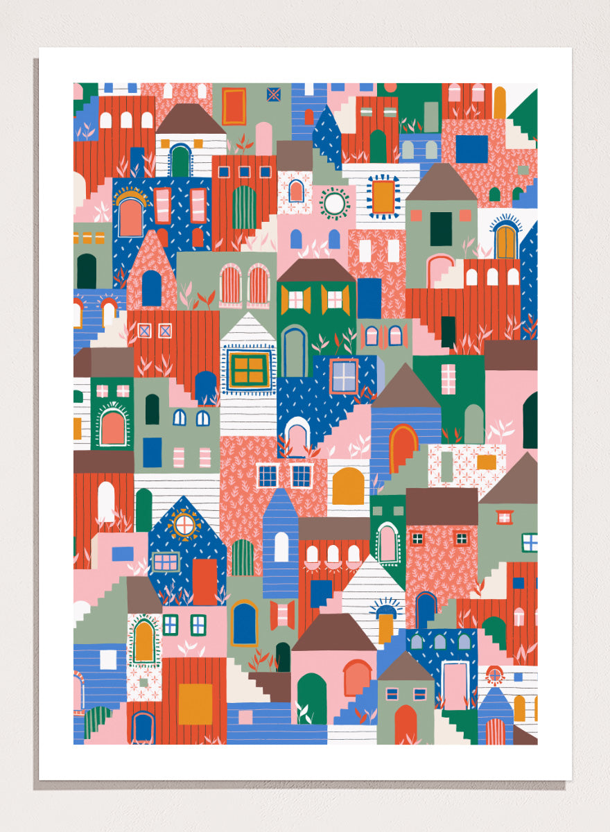A colorful art print featuring a dense, stylized illustration of houses and buildings in a playful, patterned village scene. Whimsical Cityscape Charm by Ceyda Alasar city art print featuring stacked colorful houses, patterned walls, winding stairs, and playful architectural details.