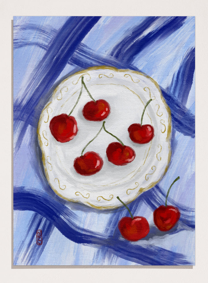 Painting of cherries on a white plate with a blue background. Red Cherries Blue Table by Dirkie Nell is a contemporary fruit still life art print featuring hand painted cherries, blue table linens, and colorful kitchen wall art style.