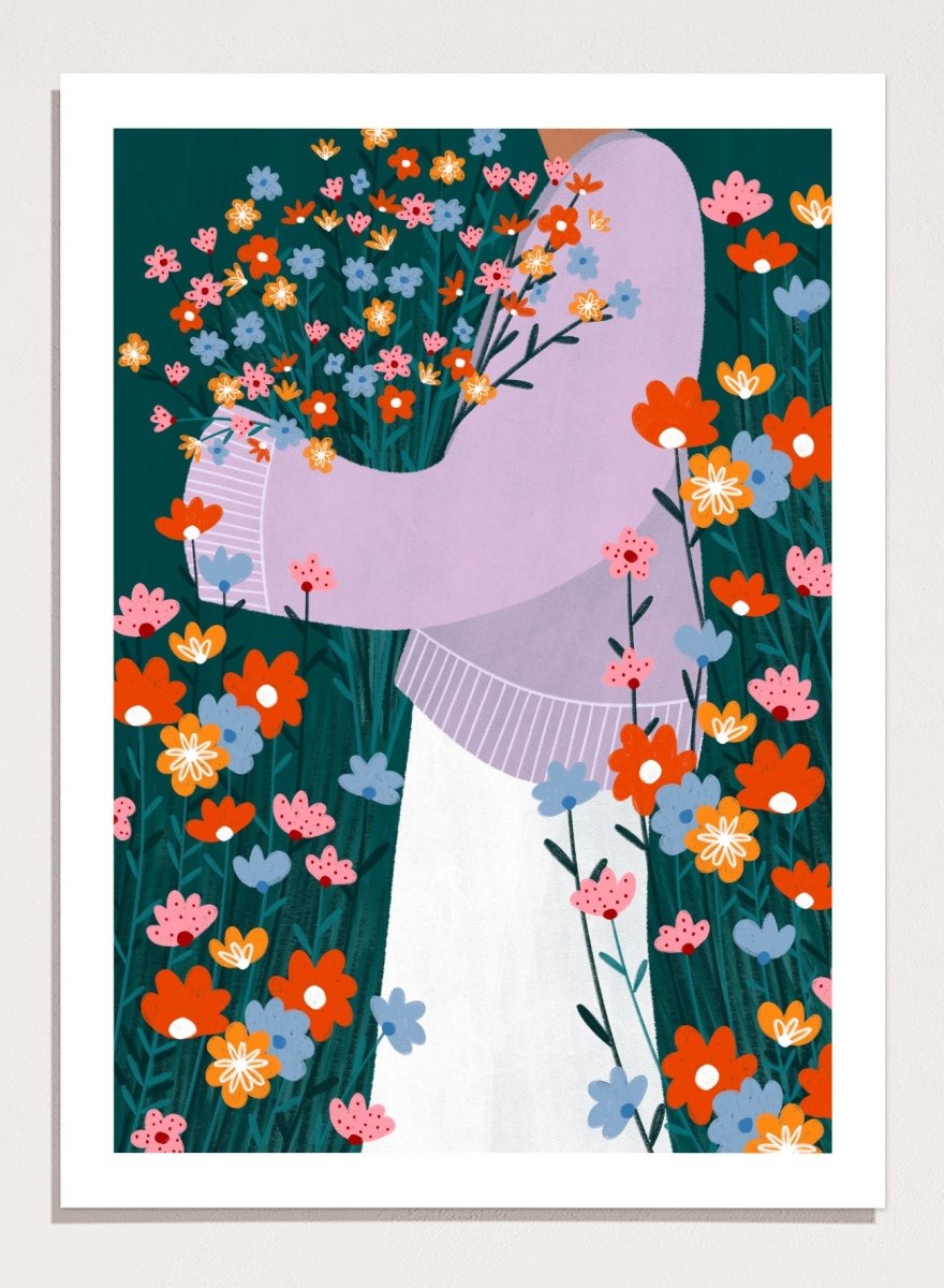 A stylized art print featuring a woman in a lavender sweater and white skirt holding a large bouquet of colorful wildflowers, framed by dense flowers on a dark teal background. Happy Woman Holding Flowers by Bea Müller premium framed fine art print featuring a woman carrying wildflowers in bright orange, pink, blue, and teal.