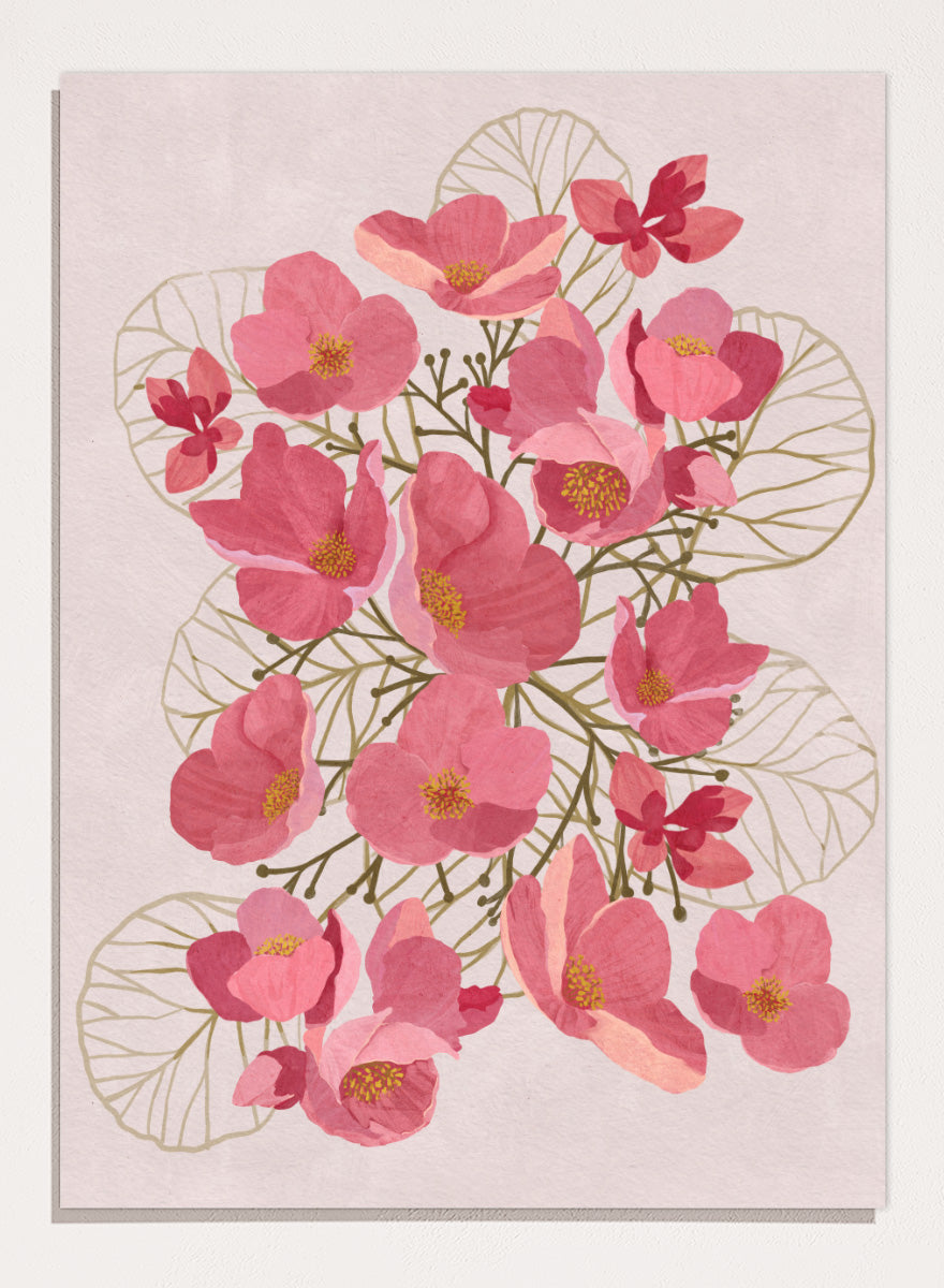 A framed botanical art print featuring pink flowers with yellow centers and delicate gold leaf outlines on a pale pink background. Shop Japanese Quince Floral Art Print by Katie O&