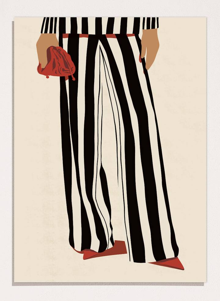 Fashion illustration of a person from the waist down wearing black and white vertically striped wide-leg trousers, with a red belt, red pointed shoes, and holding a red clutch against a cream background. Red Heels and Stripes by Lisa Solomoniuk premium framed fine art print featuring bold black-and-white stripes, pointed red heels, and a matching bag.
