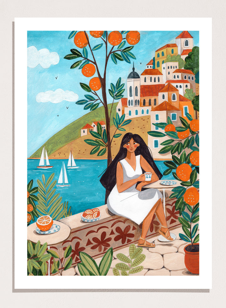 Woman in a white dress sitting under an orange tree with a scenic coastal town in the background. Mediterranean Orange Grove View by Caroline Bonne Müller fine art print, wall art poster with coastal scene, orange trees, modern aesthetic design