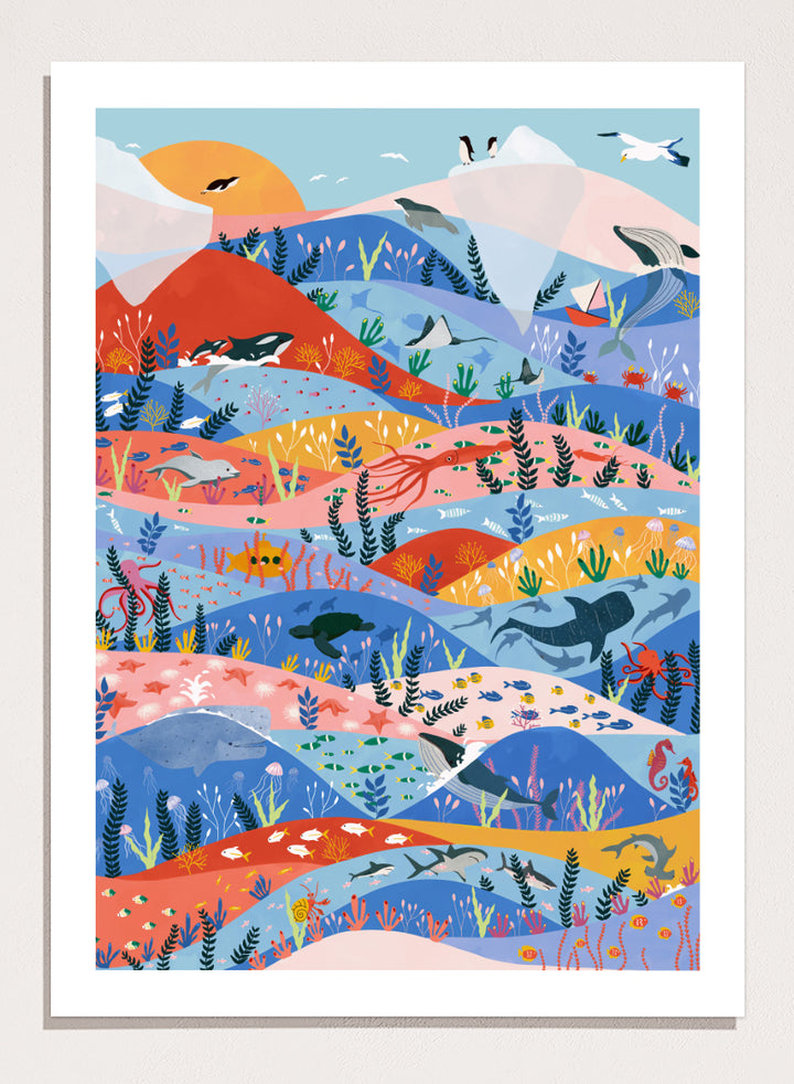 A colorful illustrated art print featuring stylized mountains, sea life, and coastal scenery in layered wavy bands of blue, pink, orange, yellow, and green. Vibrant Ocean Life by Ceyda Alasar ocean art print featuring whales, sharks, rays, turtles, coral reefs, sea plants, and colorful marine life.