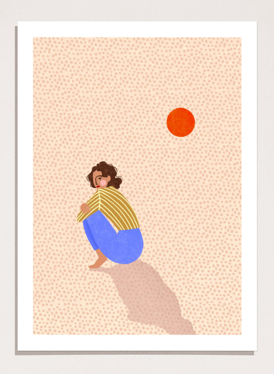 A minimalist art print featuring a stylized illustration of a person crouching in blue pants and a yellow striped top, looking up at a small orange sun against a light beige dotted background, framed with a white mat and black border. Pensive Woman Under Sun by Bea Müller art print featuring a seated woman beneath an orange sun in bold blue, mustard, and soft neutral tones.