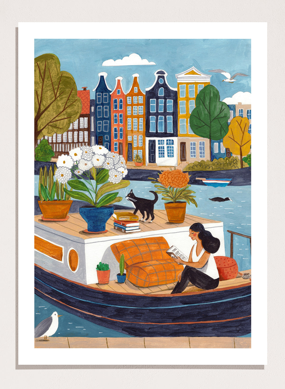 Illustration of a woman on a boat with flowers and a cat, surrounded by colorful houses. Cozy Canal Reading by Caroline Bonne Müller is a fine art print and wall poster featuring a woman reading on a canal boat with colorful European buildings in the background.