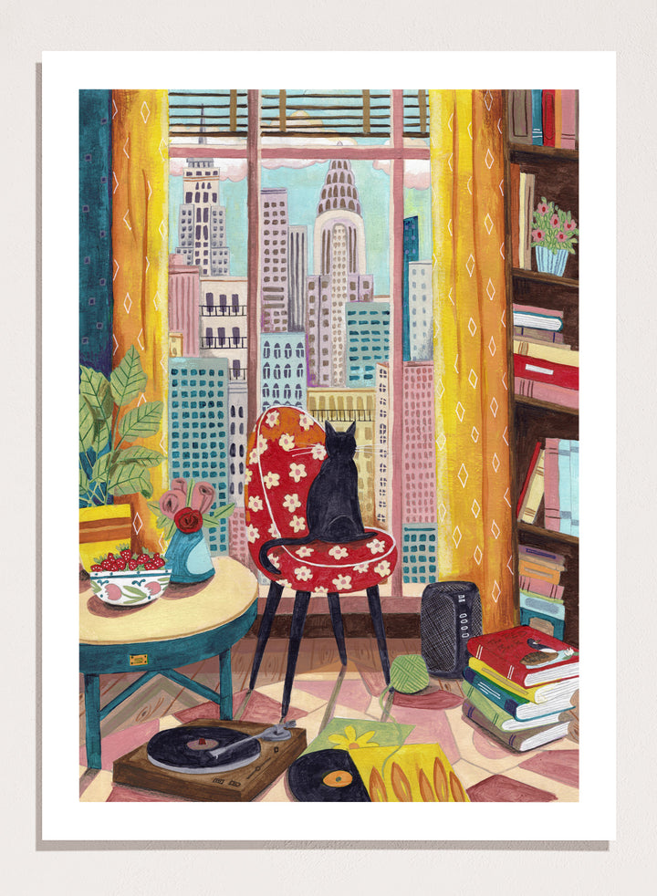 Colorful interior scene with a cat on a chair, books, and cityscape view. Black Cat City View by Caroline Bonne Müller is a fine art print and wall poster of a black cat by a window with city skyline and colorful interior.