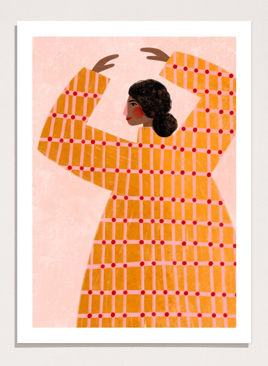 A framed art print featuring a stylized illustration of a woman in profile wearing a bright orange dress with a red grid pattern, set against a pale pink background. Dancing Woman in Orange by Bea Müller premium fine art print featuring a bold figure, warm orange tones, and a playful graphic composition.