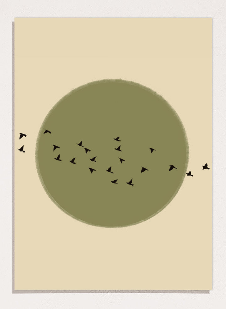 Minimalist art print featuring a large olive green circle with small black bird silhouettes flying across it, set against a warm beige background. Graceful Birds Soaring by The Art Concept is a minimalist bird art print featuring black birds in flight across an olive green circle and warm cream background.