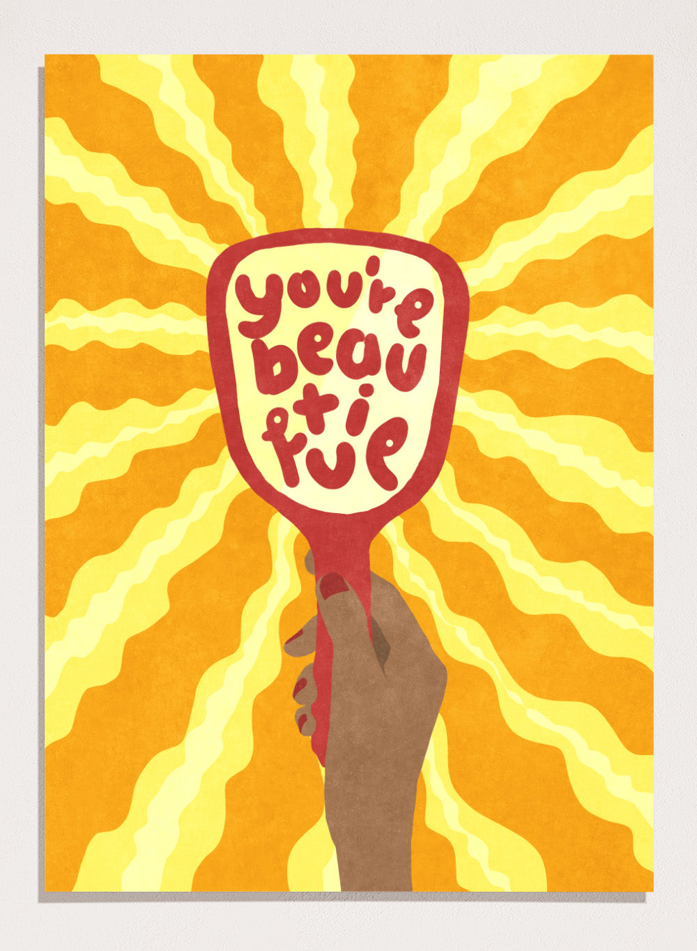 Hand holding a sign with 'You're beautiful' on an orange and yellow background. Beautiful by Raissa Oltmanns is a modern motivational art print featuring a hand mirror illustration, bold lettering, and bright statement wall poster style.
