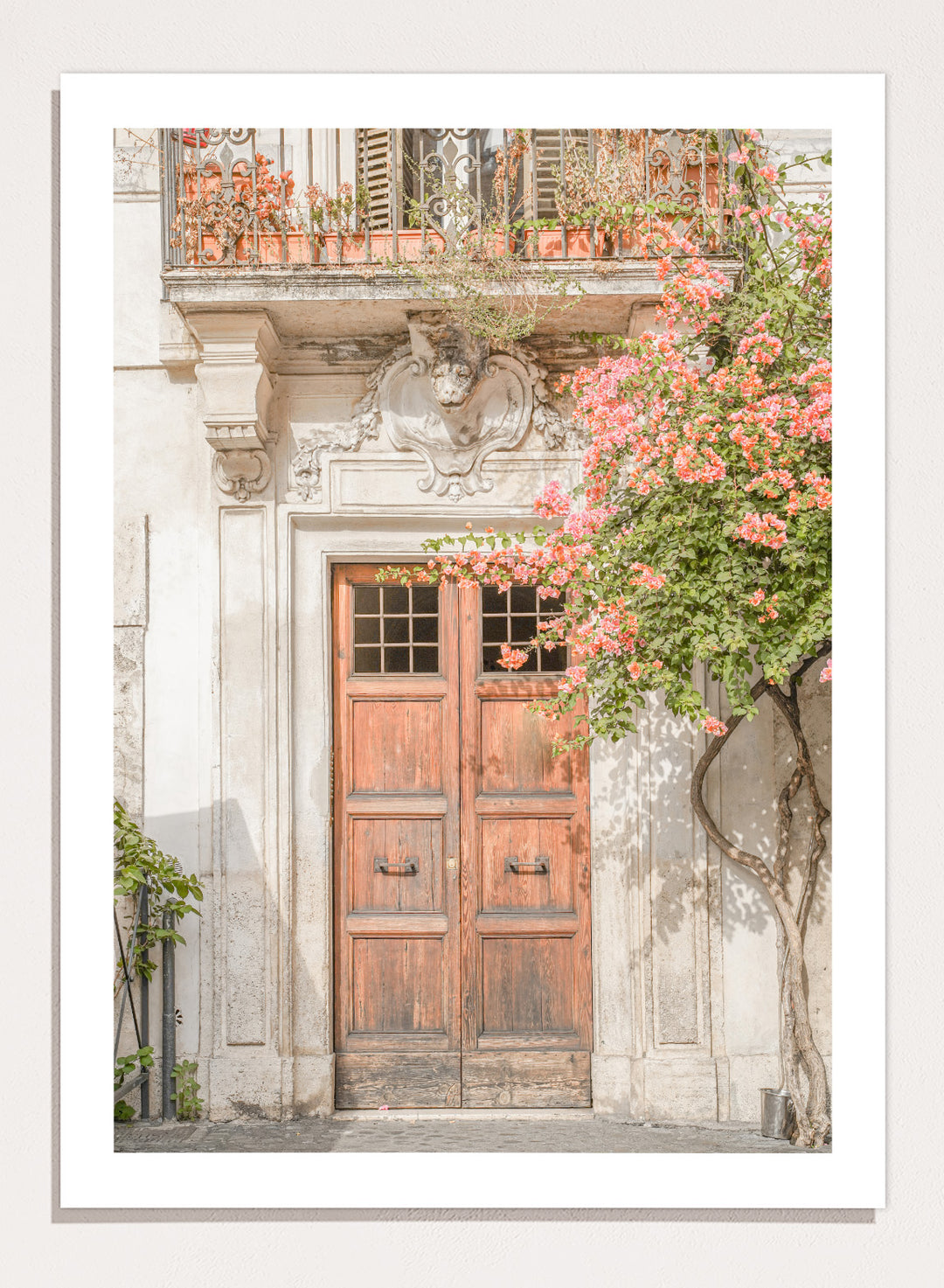 Wooden door with floral decorations on a building facade. Floral Entry by Henrike Schenk is a Mediterranean photography print featuring an old European doorway, blooming flowers, and historic architecture.