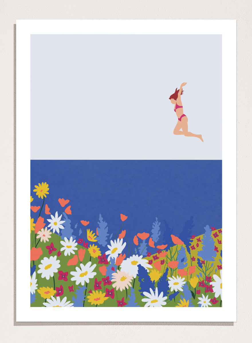 A framed art print featuring a minimalist illustration of a woman in a pink bikini jumping into a blue sea with a colorful wildflower meadow below. Wildflower Summer Jump art print by Ceyda Alasar features a joyful figure above colorful blooms, bringing playful summer energy to your walls.