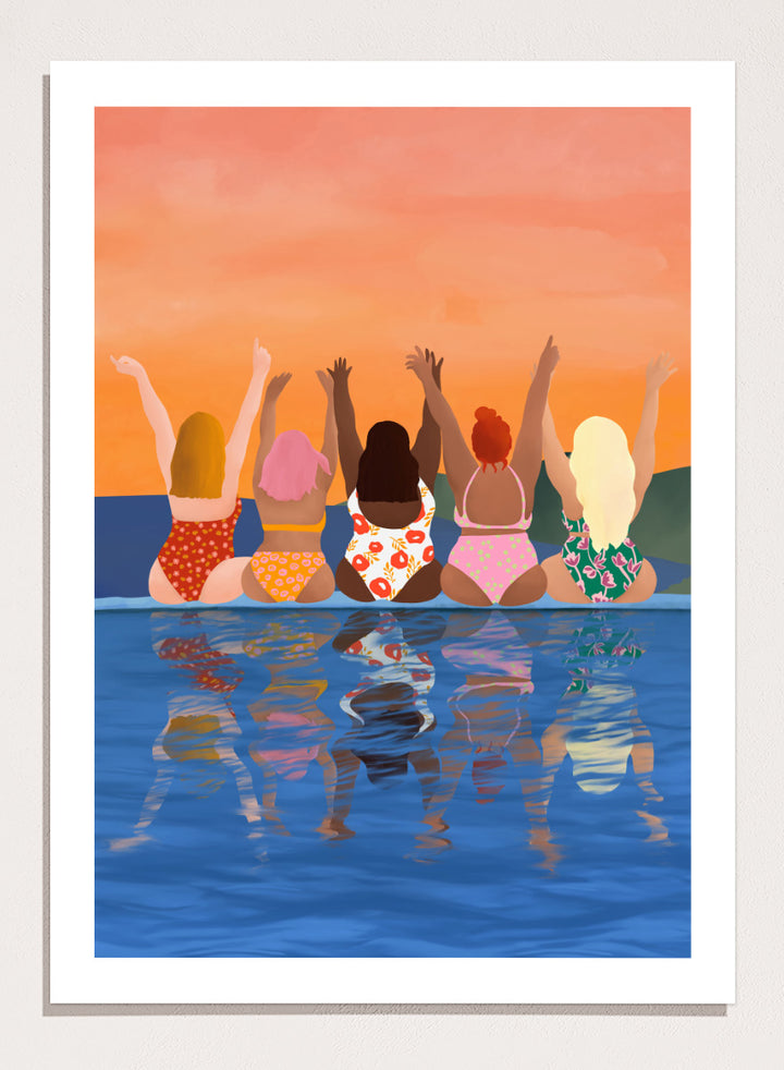 A framed art print featuring a stylized illustration of five women sitting in a pool at sunset, seen from behind as they raise their arms. The background is a warm orange sky, and the water below reflects their silhouettes. Summer Sunset Friends by Ceyda Alasar friendship art print featuring five women by the water in patterned swimsuits beneath a glowing orange sky.