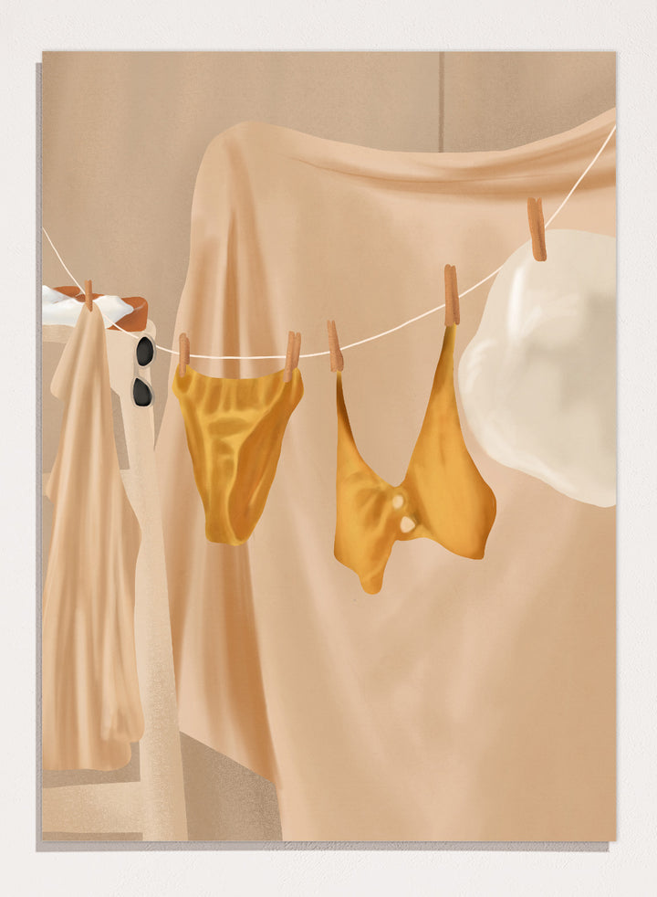 Yellow bikini top and bottom hanging on a clothesline against a beige background. Golden Summer Laundry by Flow Line is a summer art print featuring hanging linens, a yellow swimsuit, sun hat, and Mediterranean-inspired coastal decor.