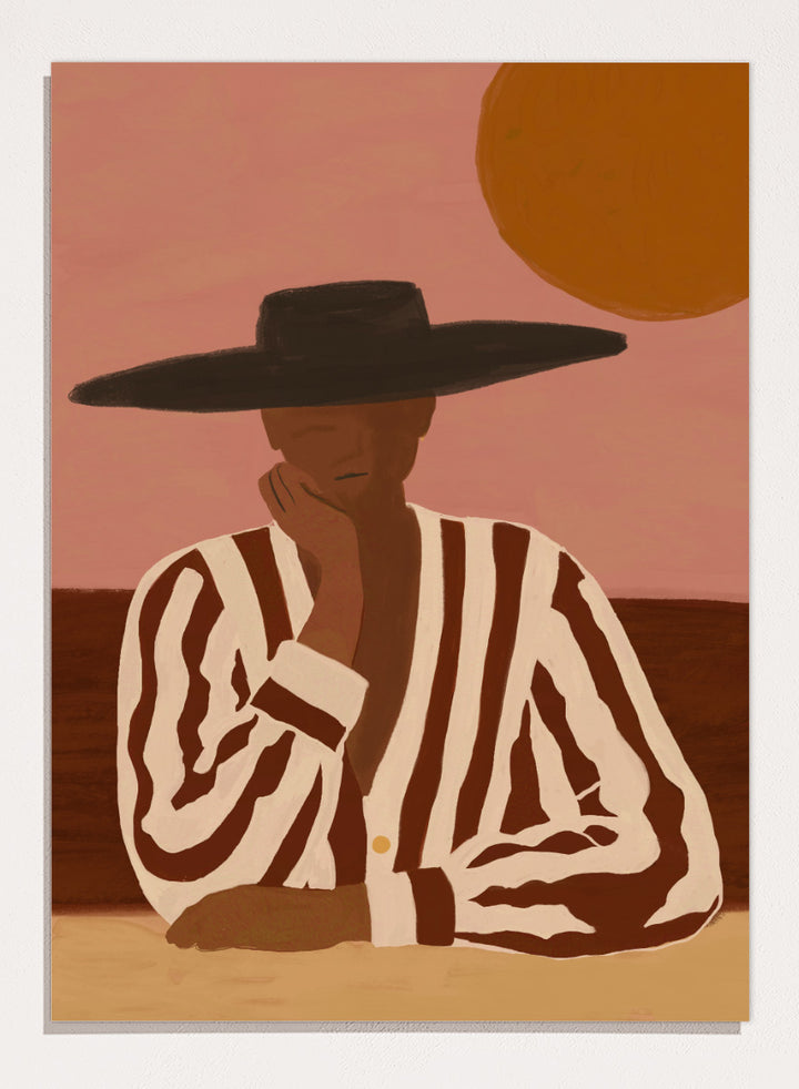 A stylized art print depicting a seated figure in a wide-brimmed black hat and a brown-and-white vertically striped shirt, set against a dusty pink sky with a large orange sun. Desert Dreamer by The Art Concept art print featuring a relaxed figure in a wide black hat, striped shirt, dusty pink sky, and warm desert-inspired tones.