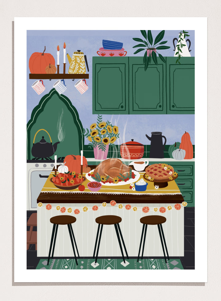 A framed art print depicting a cozy, stylized autumn kitchen scene with a large roasted turkey on a table covered in fall dishes, green cabinets, pumpkins, and three bar stools. Cozy Thanksgiving Kitchen by Ceyda Alasar kitchen art print featuring a turkey feast, pie, pumpkins, flowers, candles, and warm autumn decor.