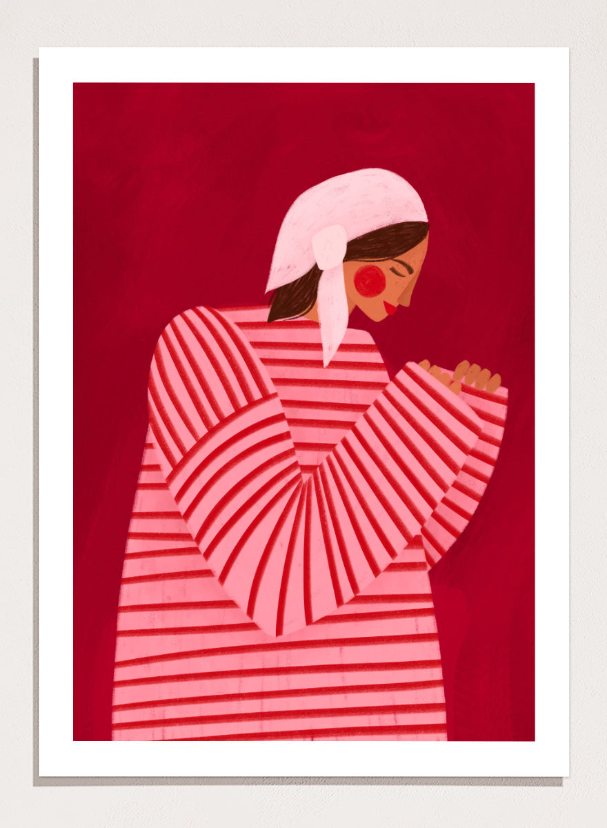 A framed art print featuring a stylized illustration of a woman in a pink and red striped top and white headscarf against a deep red background. Serene Praying Woman by Bea Müller portrait art print featuring a reflective woman in a pink striped dress against a rich red background.