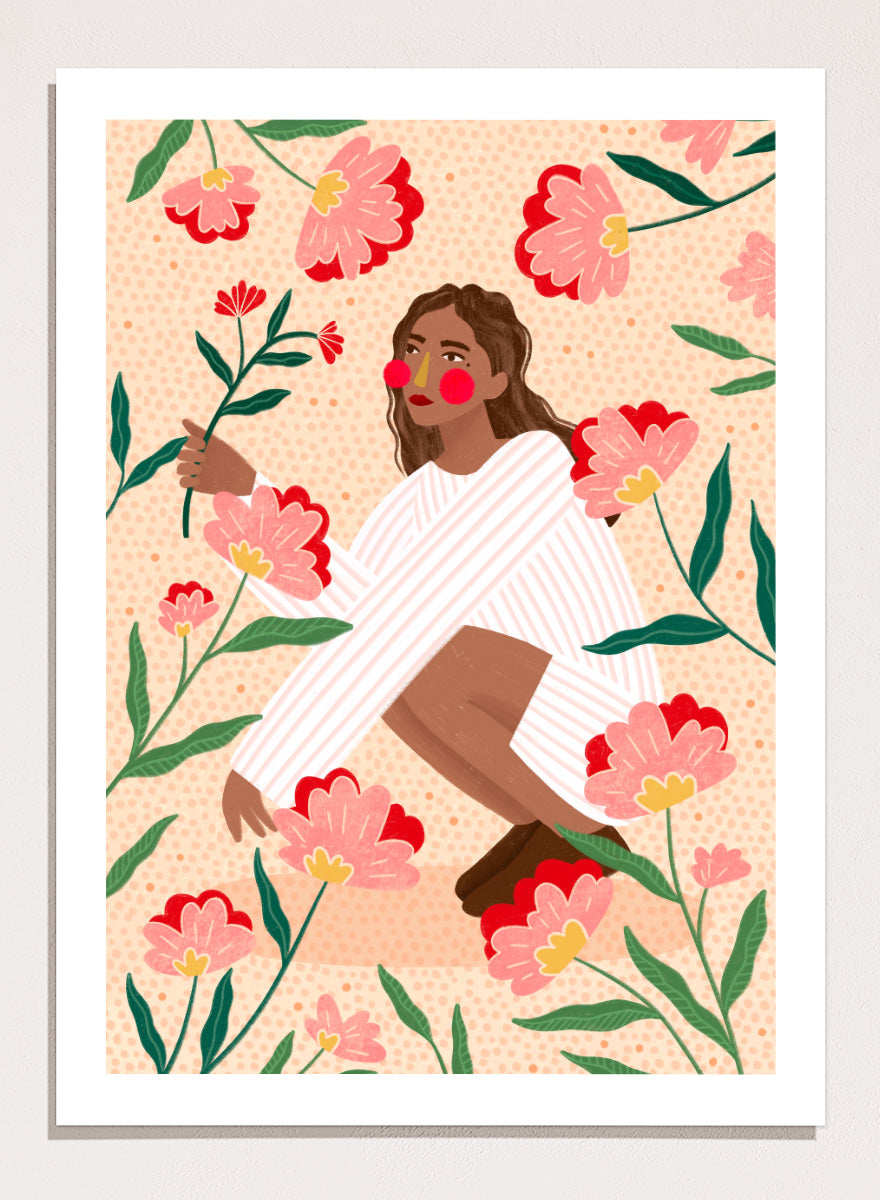 A framed art print featuring a stylized illustration of a woman in a white striped sweater surrounded by pink and red flowers on a peach background. Woman in Floral Garden by Bea Müller floral art print featuring a woman surrounded by oversized pink flowers, green leaves, and playful botanical details.