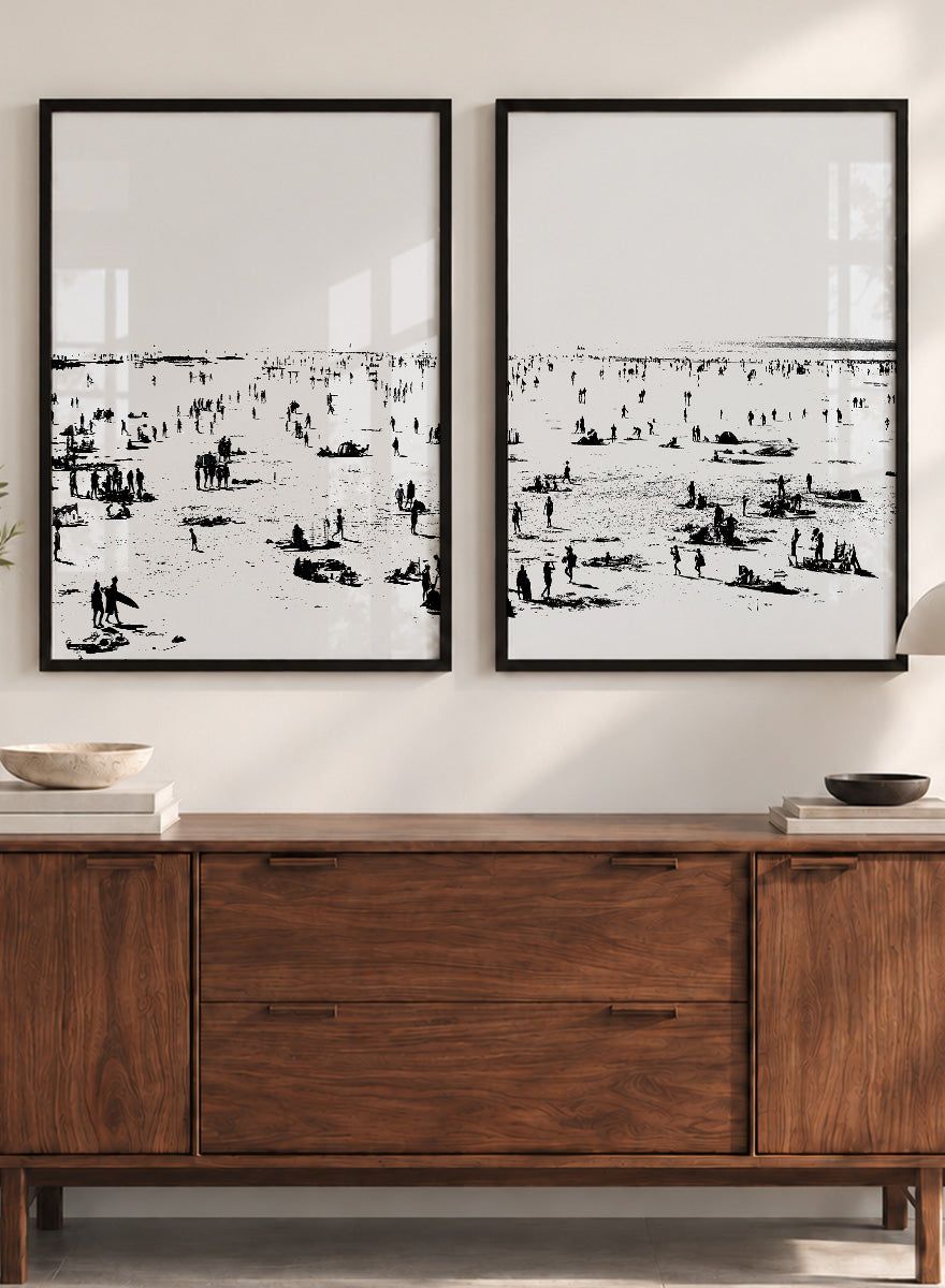 Shop Beach No.02 by Dan Hobday, a set of 2 black and white beach wall art prints posters featuring a panoramic shoreline filled with tiny figures.