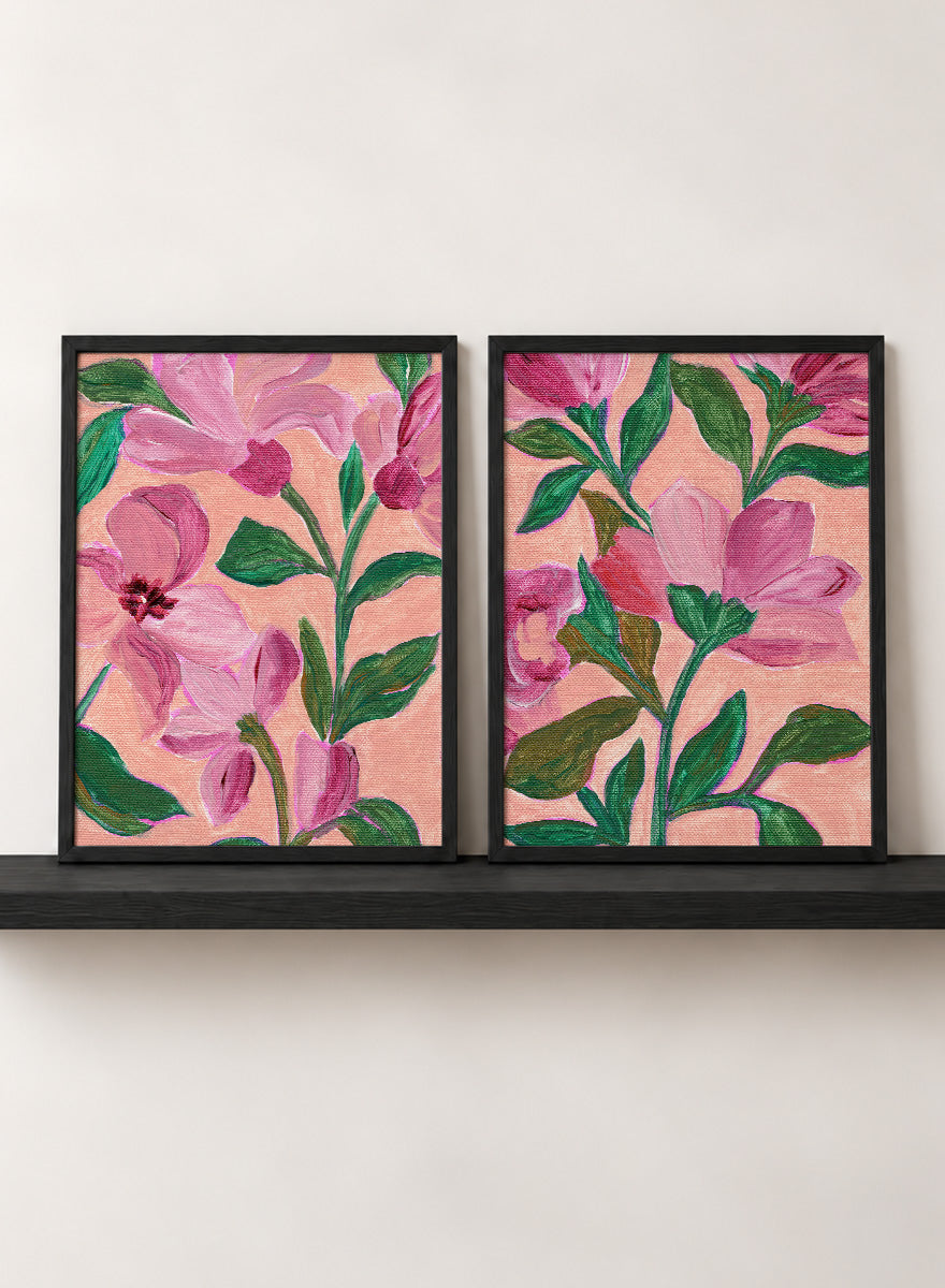 Two framed floral art prints with pink flowers and green leaves on a peach background. Shop Vibrant Pink Botanicals by Nikita Jariwala, a set of 2 floral wall art prints posters featuring oversized pink flowers and lush botanical artwork.