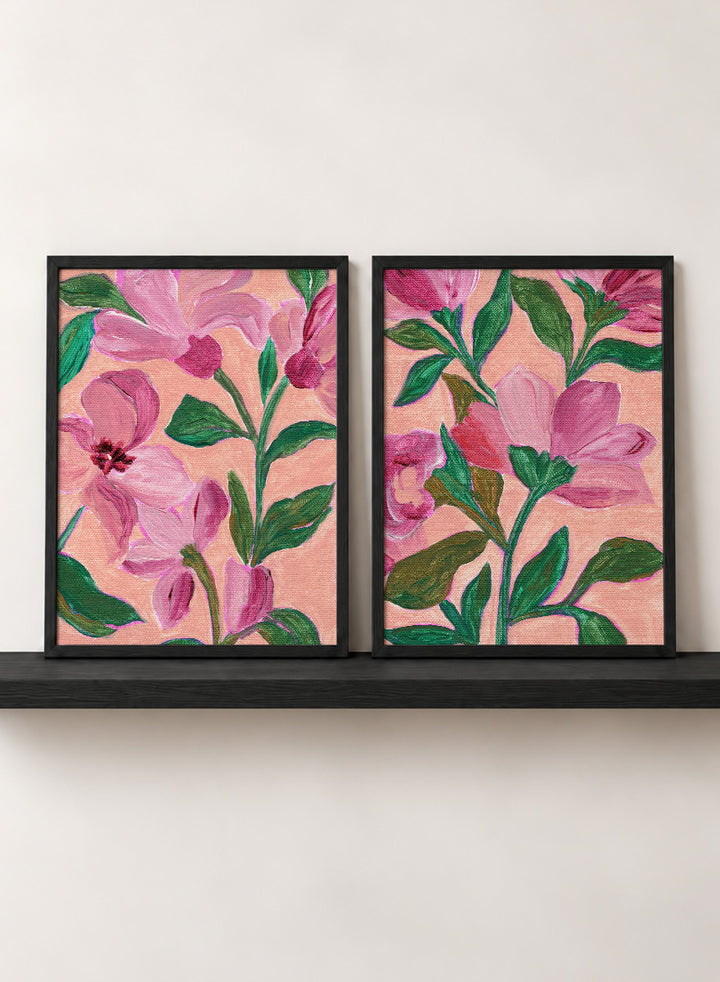 Two framed floral art prints with pink flowers and green leaves on a peach background. Shop Vibrant Pink Botanicals by Nikita Jariwala, a set of 2 floral wall art prints posters featuring oversized pink flowers and lush botanical artwork.