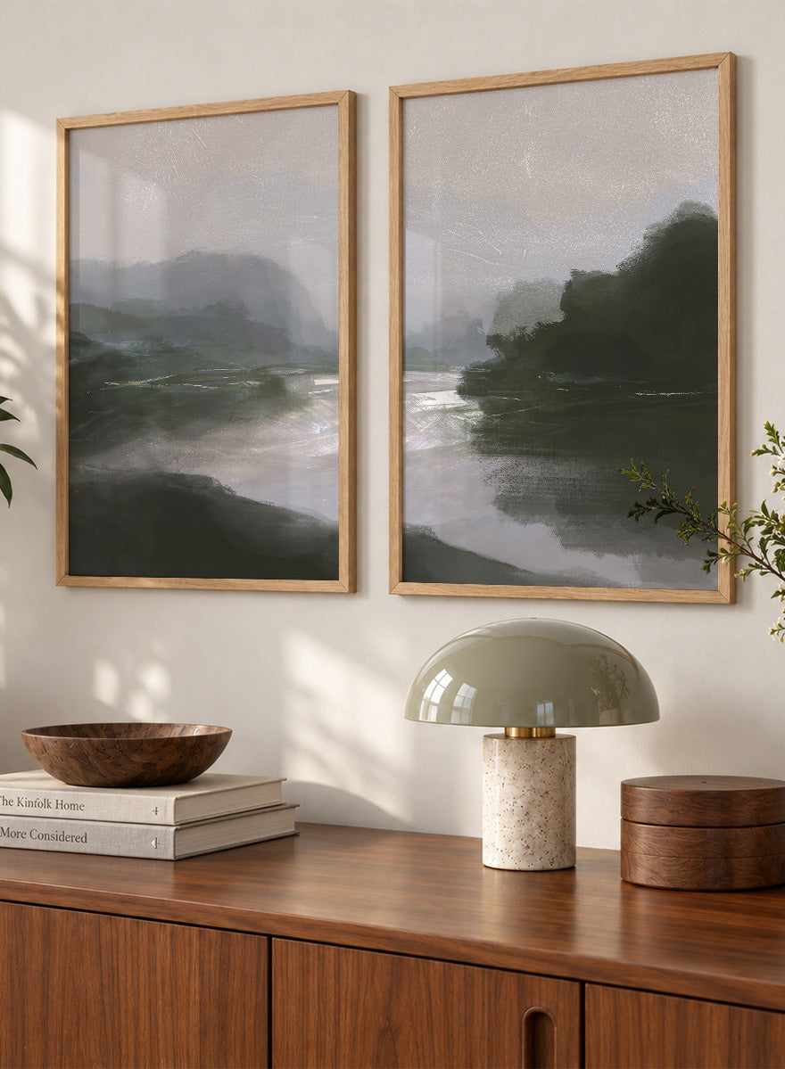 Shop Tranquillitas by Dan Hobday, a set of 2 landscape wall art prints posters featuring misty water, tree-lined banks, distant hills, and deep grey green tones.