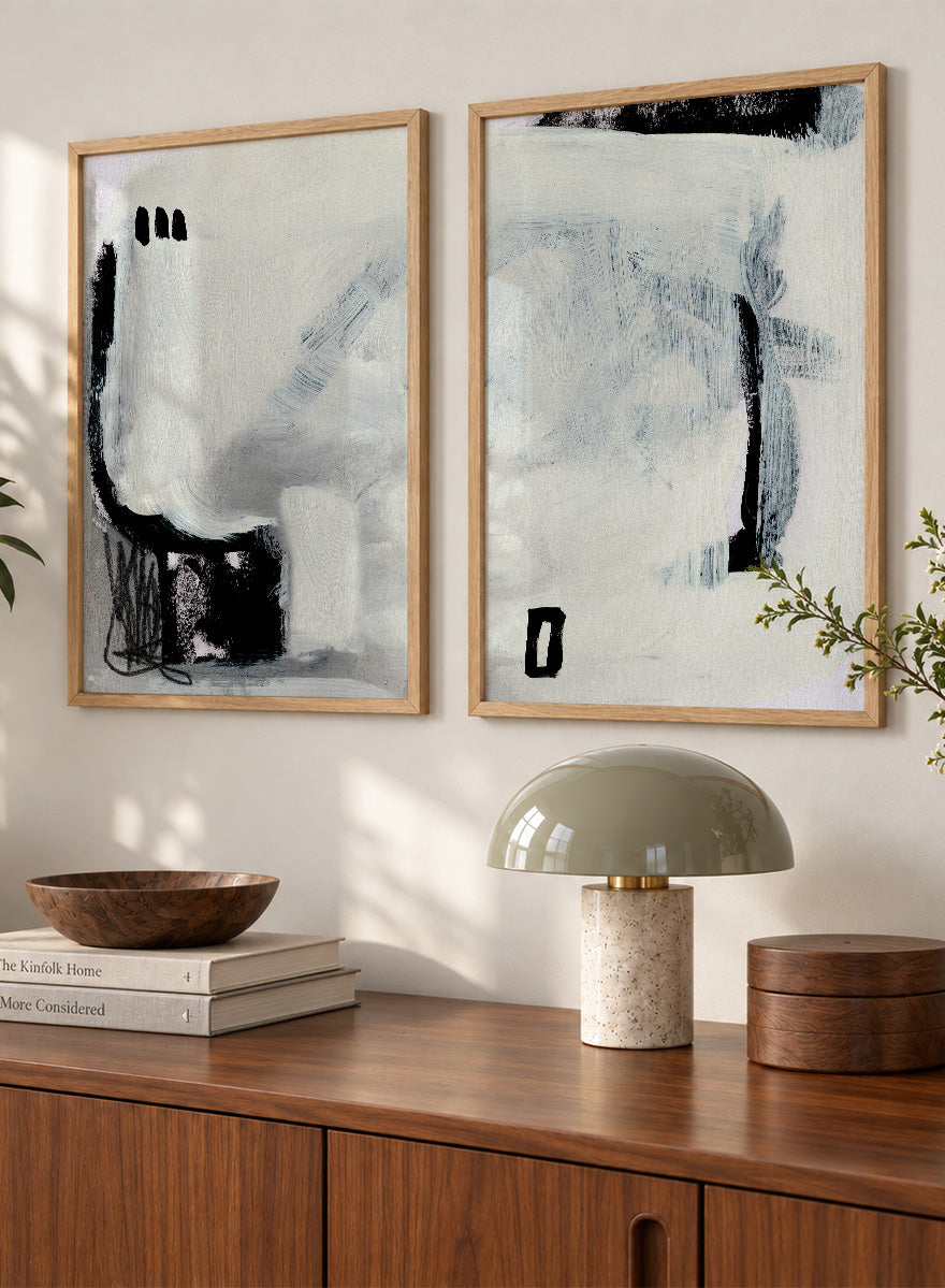 Shop Beyond by Dan Hobday, a set of 2 abstract wall art prints posters featuring expressive black forms, layered brushwork, and soft white and blue tones.
