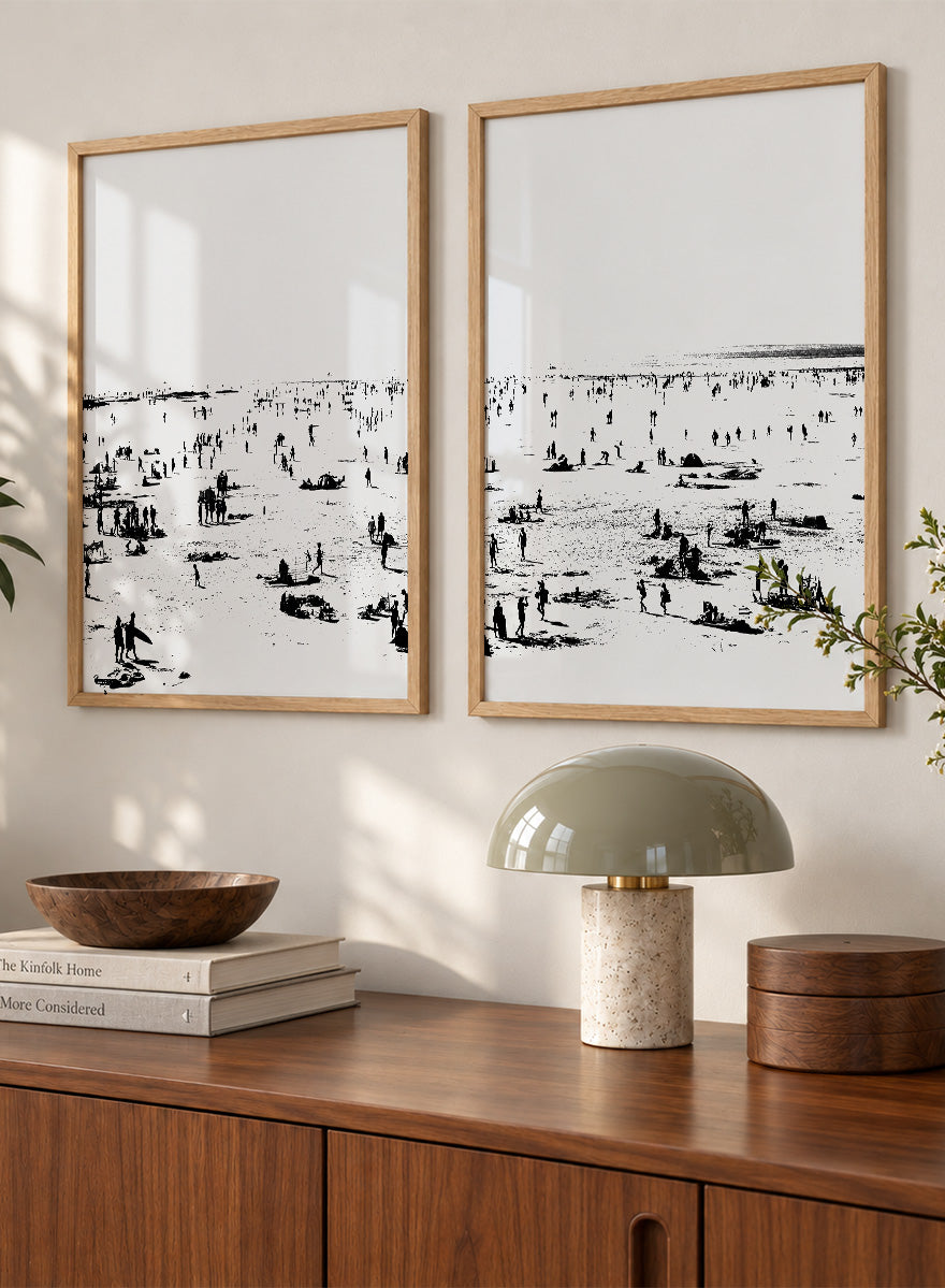 Shop Beach No.02 by Dan Hobday, a set of 2 black and white beach wall art prints posters featuring a panoramic shoreline filled with tiny figures.