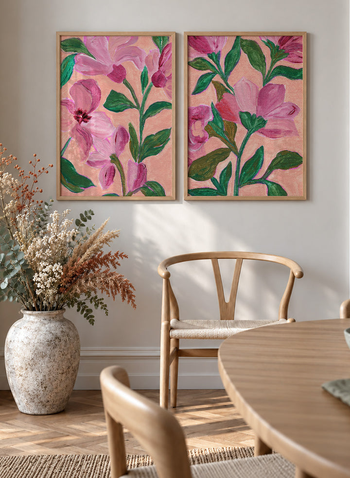 Two framed floral art prints with pink flowers and green leaves on a peach background. Shop Vibrant Pink Botanicals by Nikita Jariwala, a set of 2 floral wall art prints posters featuring oversized pink flowers and lush botanical artwork.