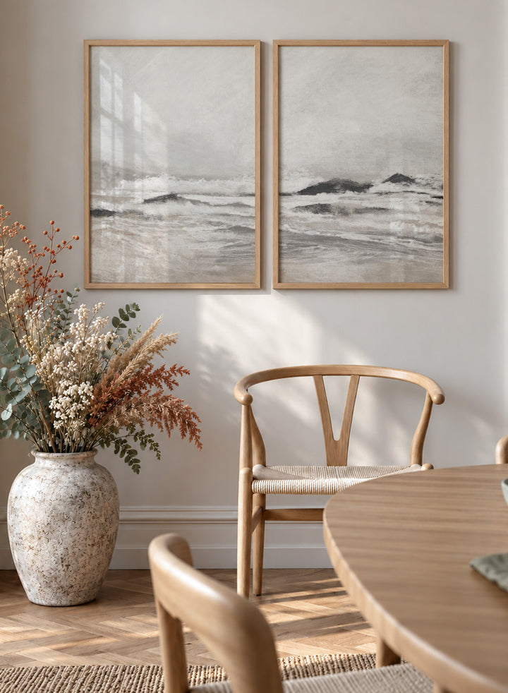 Shop September Coast by Dan Hobday, a set of 2 coastal wall art prints posters featuring rolling waves, dark rocks, misty skies, and soft neutral tones.