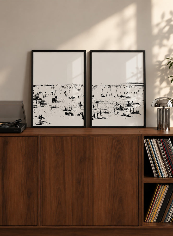 Shop Beach No.02 by Dan Hobday, a set of 2 black and white beach wall art prints posters featuring a panoramic shoreline filled with tiny figures.