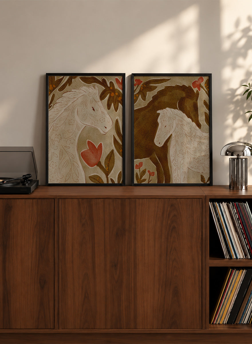 Two framed art prints depicting stylized horses in warm earthy tones. Shop Wildflower Horses by Nikita Jariwala, a set of 2 horse wall art prints posters featuring floral horse portraits, botanical details, and warm brown tones.
