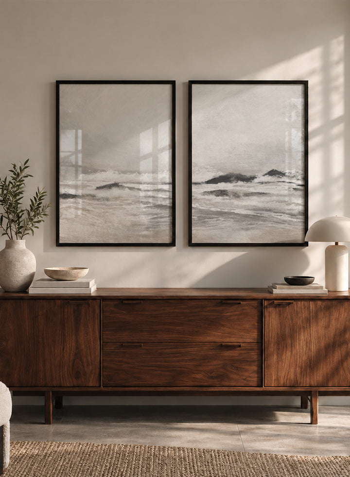 Shop September Coast by Dan Hobday, a set of 2 coastal wall art prints posters featuring rolling waves, dark rocks, misty skies, and soft neutral tones.
