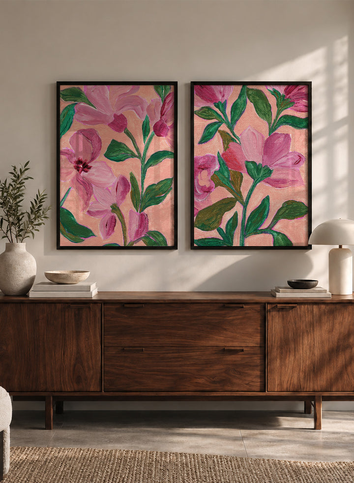 Two framed floral art prints with pink flowers and green leaves on a peach background. Shop Vibrant Pink Botanicals by Nikita Jariwala, a set of 2 floral wall art prints posters featuring oversized pink flowers and lush botanical artwork.