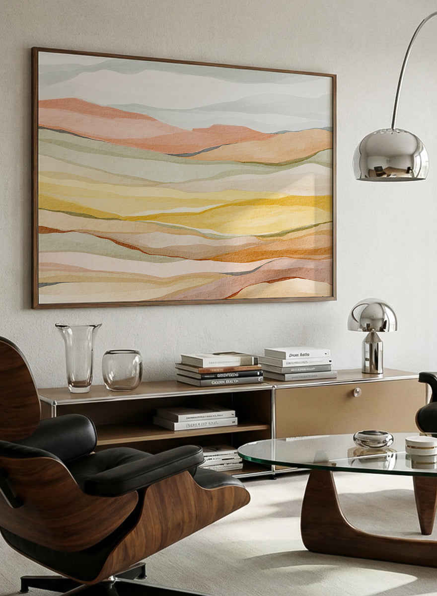 Framed abstract landscape wall art featuring layered wavy hills in soft peach, yellow, beige, and muted green tones. Shop Warm Horizon Layers by Nikita Jariwala, an abstract landscape wall art print poster with layered hills and mountains, soft yellow fields, and warm peach tones.
