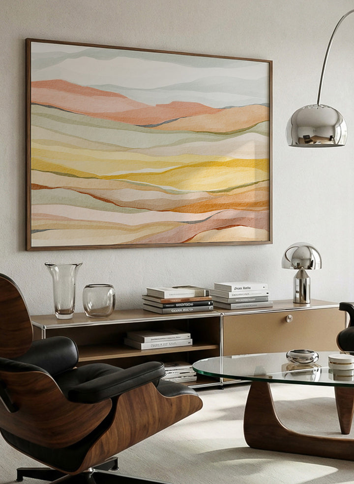 Framed abstract landscape wall art featuring layered wavy hills in soft peach, yellow, beige, and muted green tones. Shop Warm Horizon Layers by Nikita Jariwala, an abstract landscape wall art print poster with layered hills and mountains, soft yellow fields, and warm peach tones.