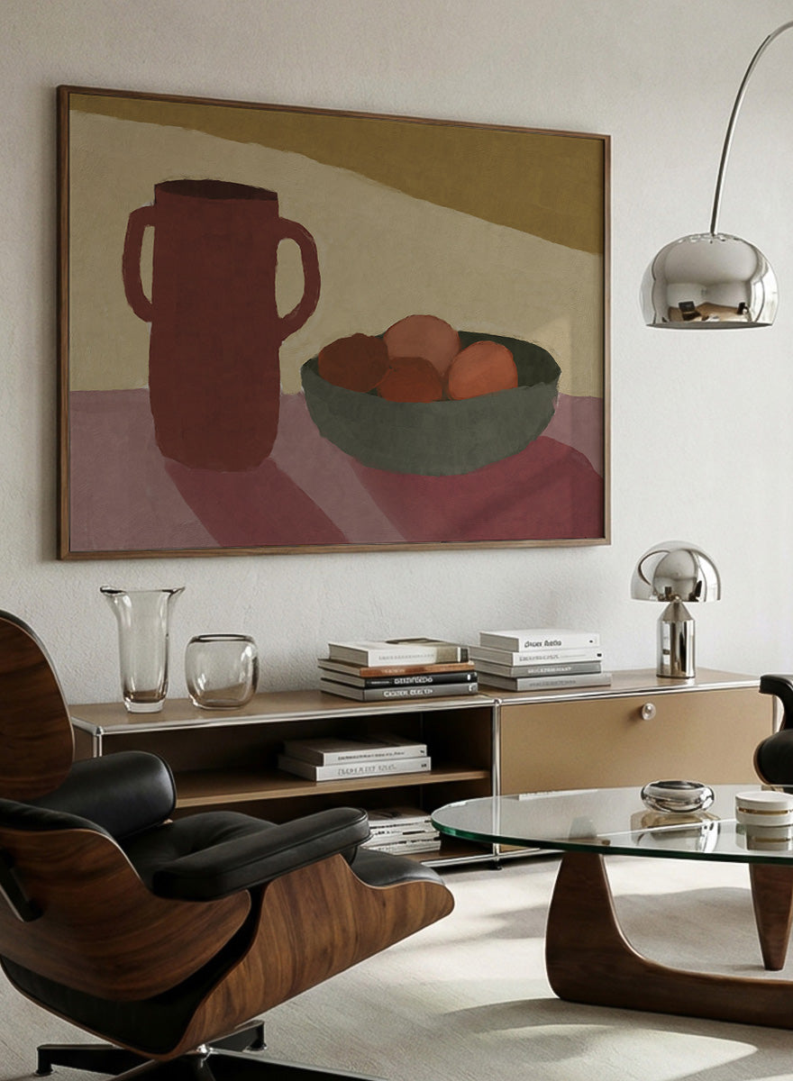 A framed still life art print featuring a dark reddish-brown pitcher and a green bowl with brown and orange fruits, set against a beige and mustard background. Shop Jug With Peaches by Dan Hobday, a contemporary still life wall art print featuring a red jug, bowl of peaches, warm earthy tones, and soft shadow.