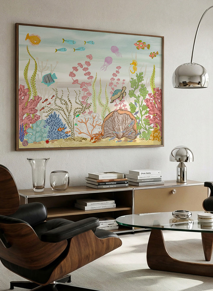 A framed art print depicting a colorful underwater scene with fish, coral, sea plants, a turtle, and a clam shell on a sandy ocean floor, shown against a light neutral background. Shop Vibrant Underwater World by Nikita Jariwala, an ocean wall art print poster with sea turtles, tropical fish, coral reef art, jellyfish, and blue tones.