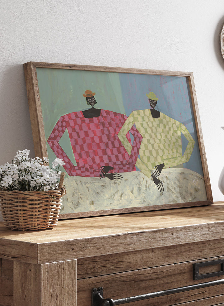 Framed artwork of two figures wearing colorful sweaters against a textured background. Opposites by Studio IMO (Ibi Meier-Oruitemeka) is a modern figurative art print with two figures, bold color contrast, and contemporary wall poster design.