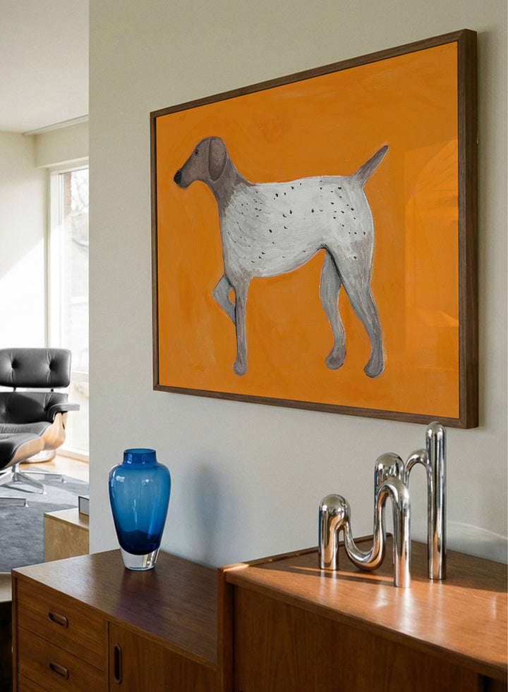 Framed artwork of a dog on an orange background. Orange Pointing Dog by Lerin Freyou is a hand painted minimal dog art print with bold orange background, modern animal poster with clean aesthetic style.